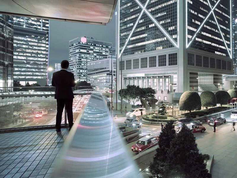 Investor standing on the balcony of a hotel in a smart city