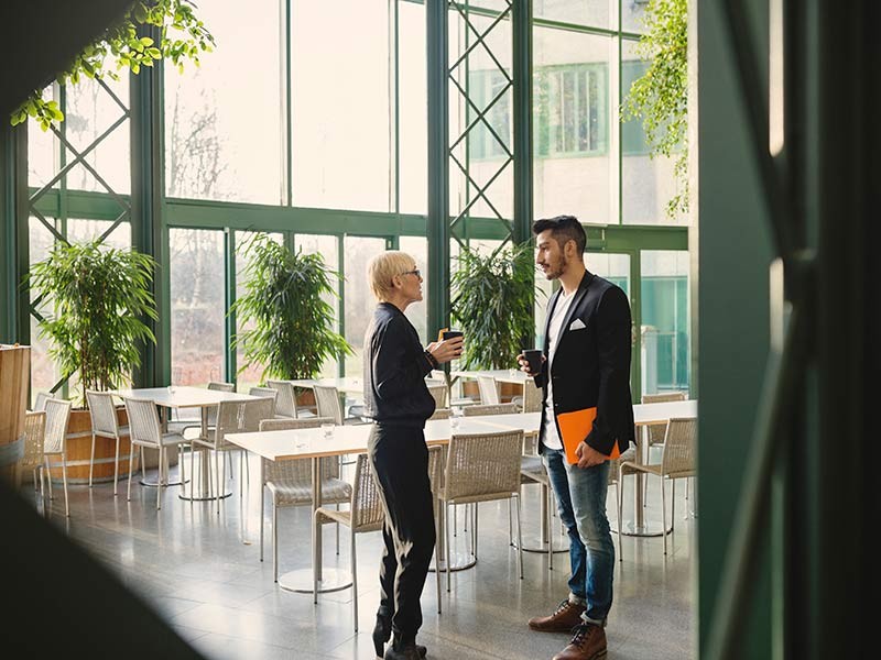 Employees at cafeteria with coffee cup