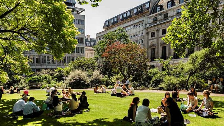 People relaxing in urban green space on a sunny day