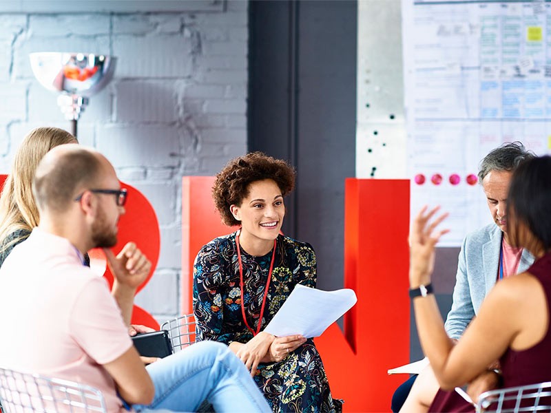 Picture of employees discussing something inside JLL office