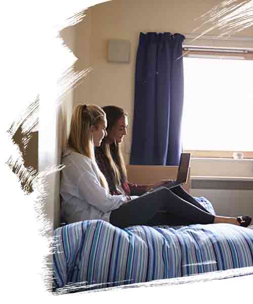 Two female students discussing a project on a laptop