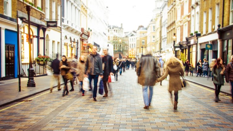 Motion blurred shoppers on busy high street