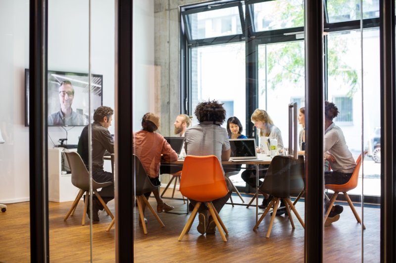 Multi-ethnic business people video conferencing in board room at office